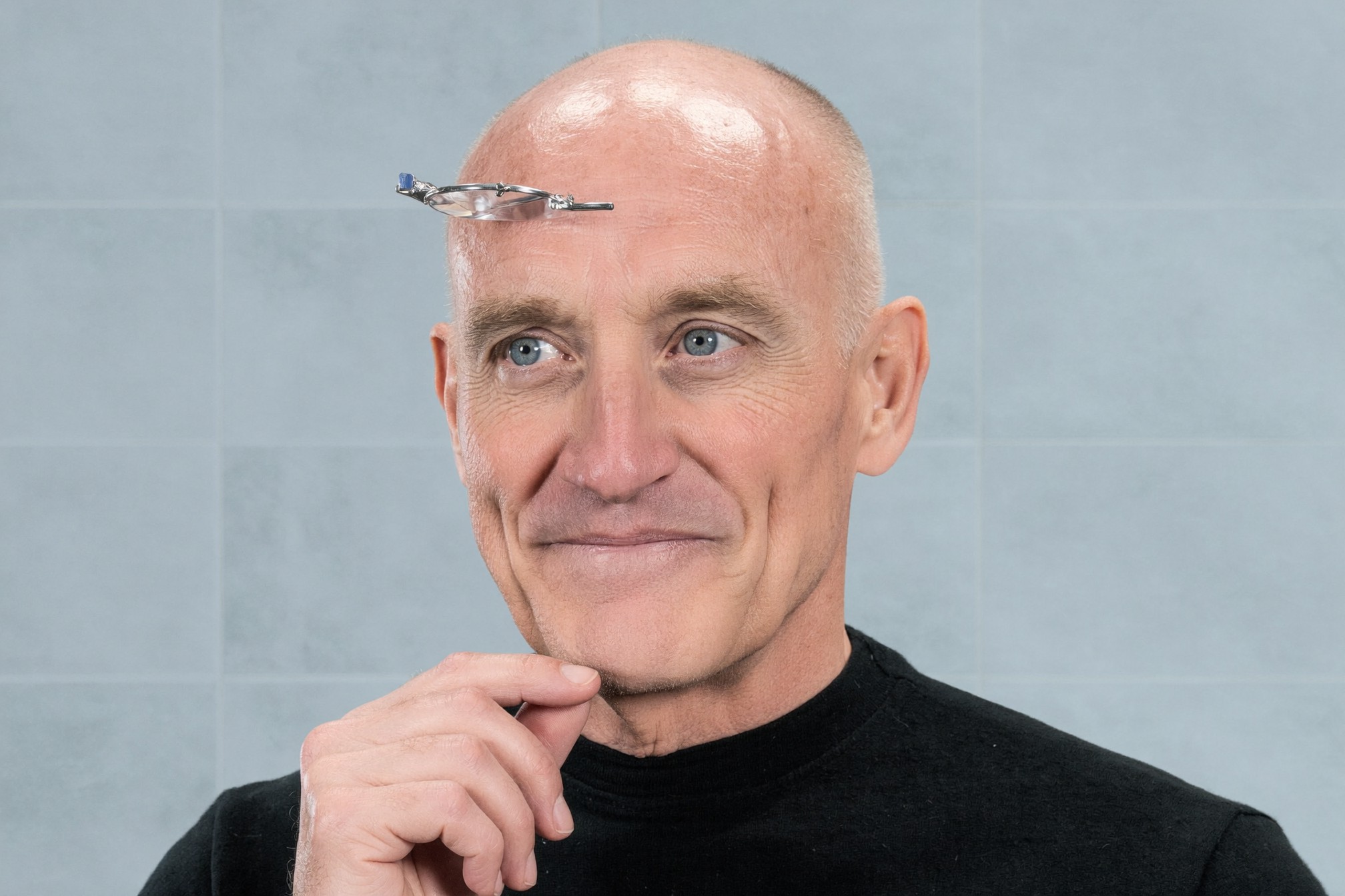 Dr. Adams studying a face, loupes pushed up on his forehead